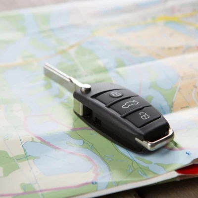 Cheie de mașină așezată pe o hartă rutieră, simbolizând planificarea unei vacanțe în România cu un autoturism închiriat.